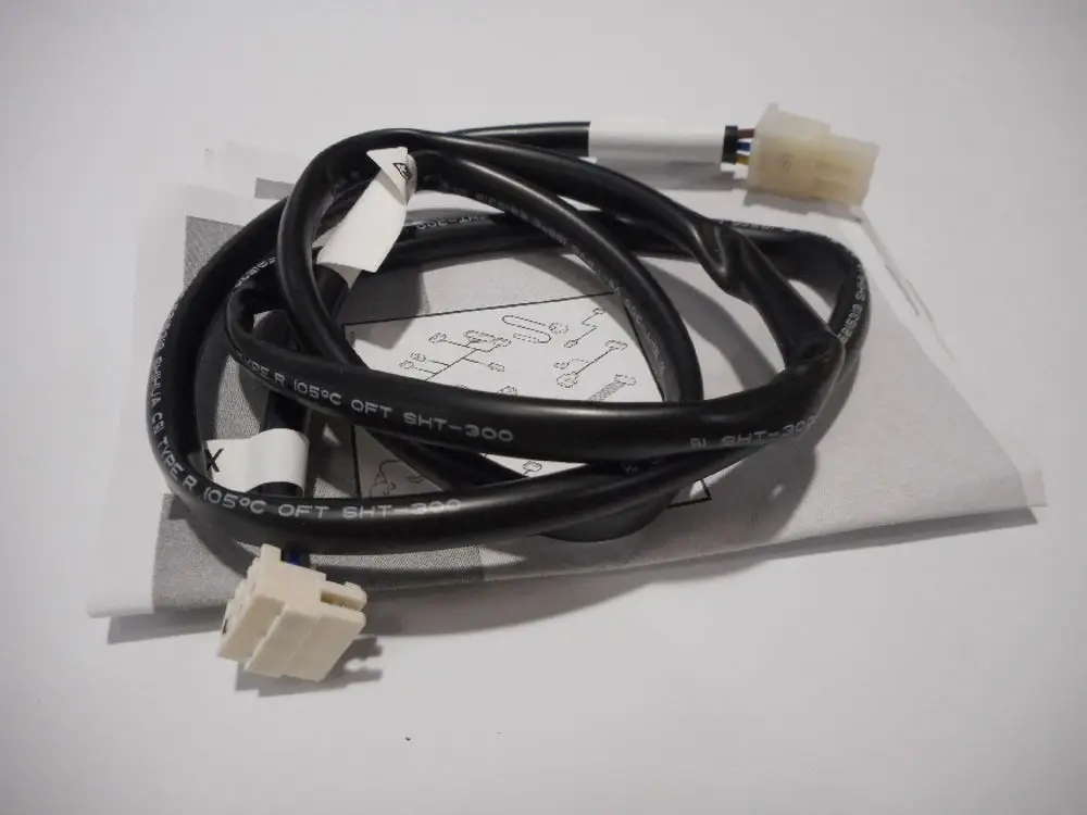 Kabel mit mehreren Anschlusssteckern, liegend auf einer Anleitung. Das Produkt gehört zur Marke Remeha und dient der Verbindung für eine Pumpe.